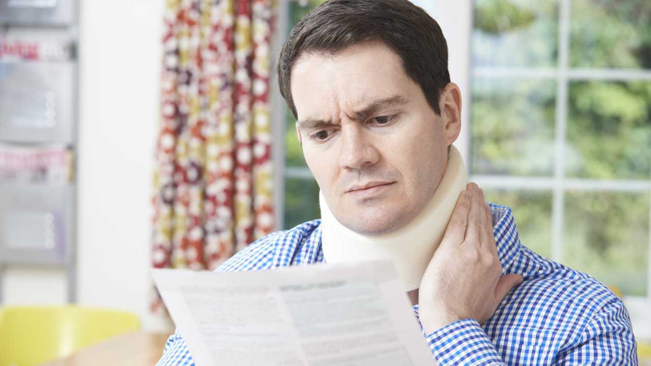 Man reading letter after receiving neck injury