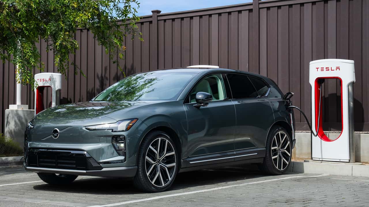 A Volvo EX60 at a Tesla Supercharger