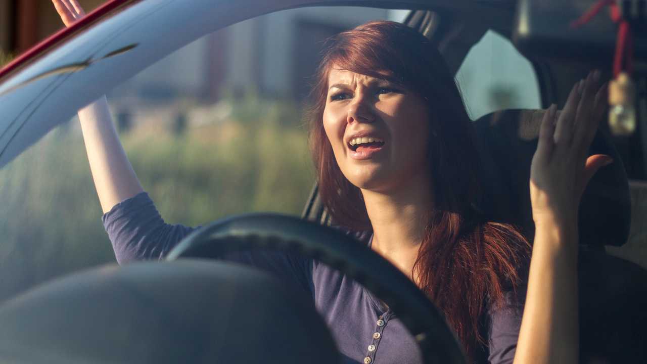 Angry young woman driver gesturing with hands