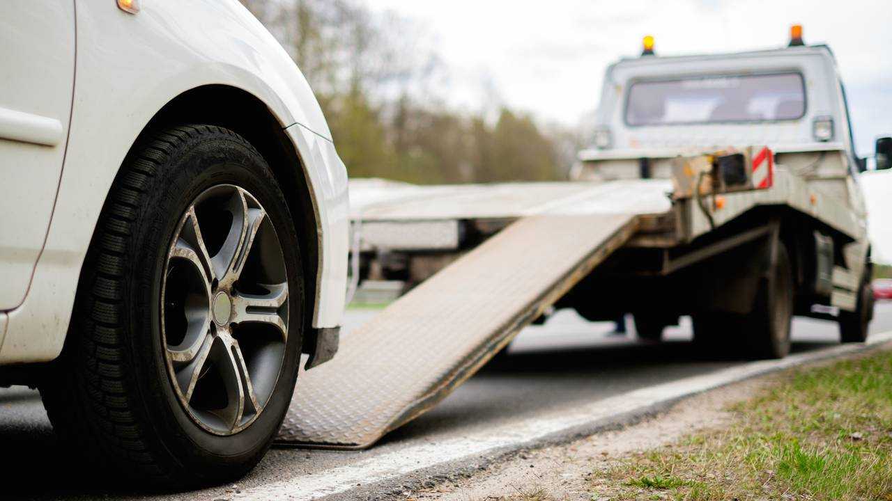 Loading broken car on a tow truck on a roadside