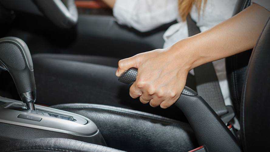 Women driver engaging handbrake
