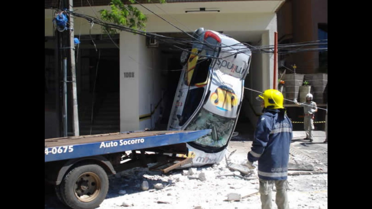 Carro cai do 3º andar de prédio e fica preso em fios de alta tensão