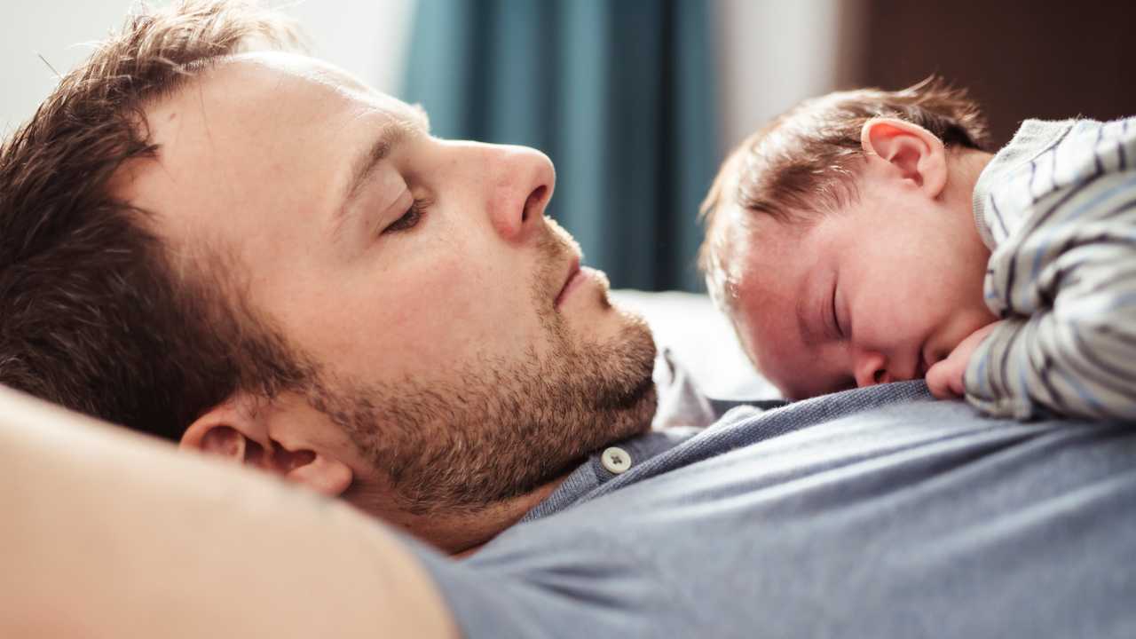 Father and baby lying in bed