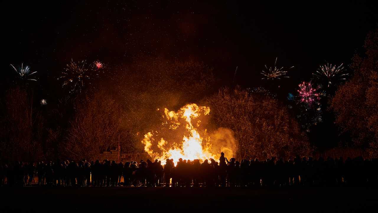 Bonfire Night crowd watch bonfire and fireworks