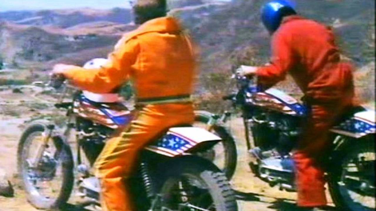 Attempting to sneak up on the bad guys on the loudest motorcycles in the county, wearing the loudest jumpsuits of the decade.