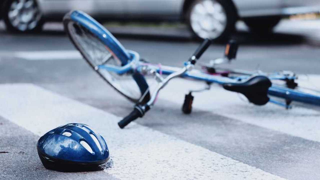 Helmet and bike lying on the road on a pedestrian crossing