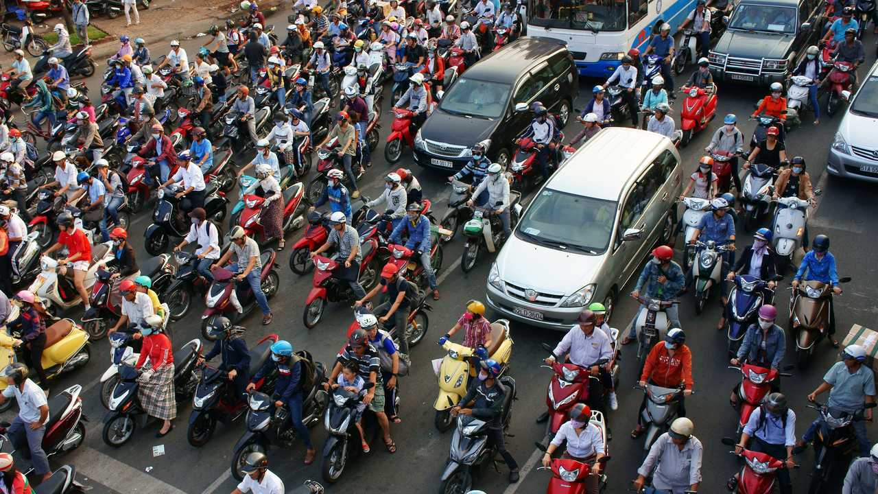 Heavy traffic with people mostly riding motorcycles Hanoi Vietnam