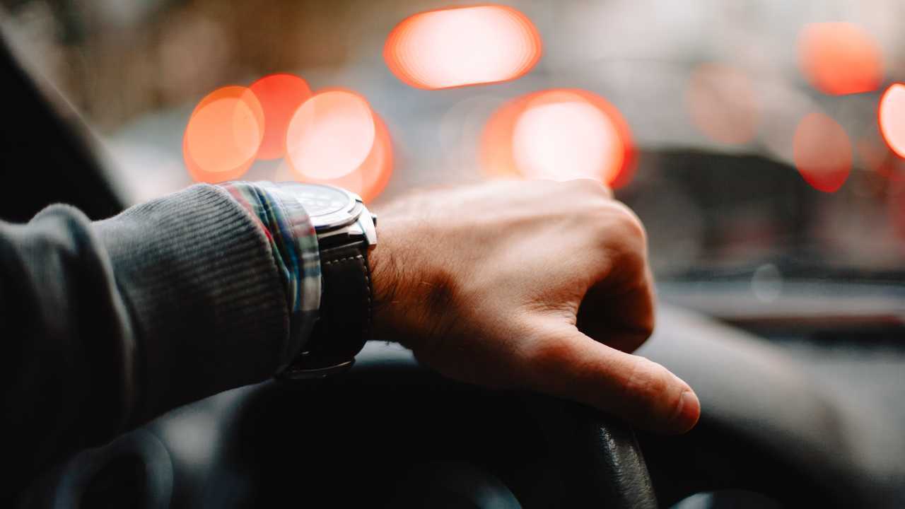 Close up of male hand on steering wheel
