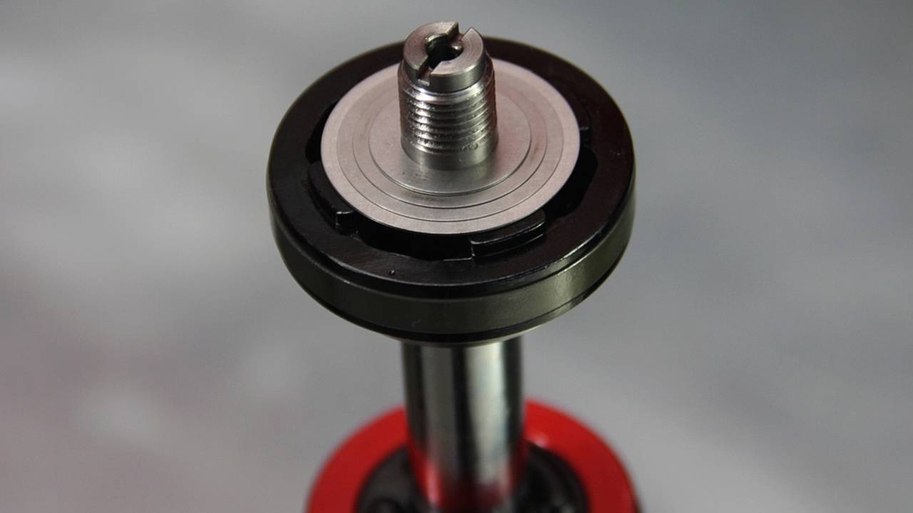 The rebound shim stack. Fluid will flow through the ports on the valve when sufficient pressure is reached to flex the shims. Changing the diameter or number of the shims changes the flow rate and pressure needed to open the valve.