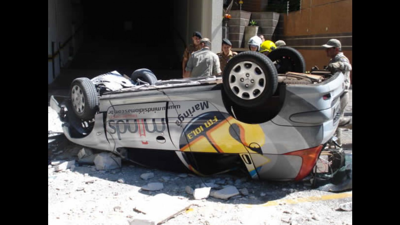 Carro cai do 3º andar de prédio e fica preso em fios de alta tensão