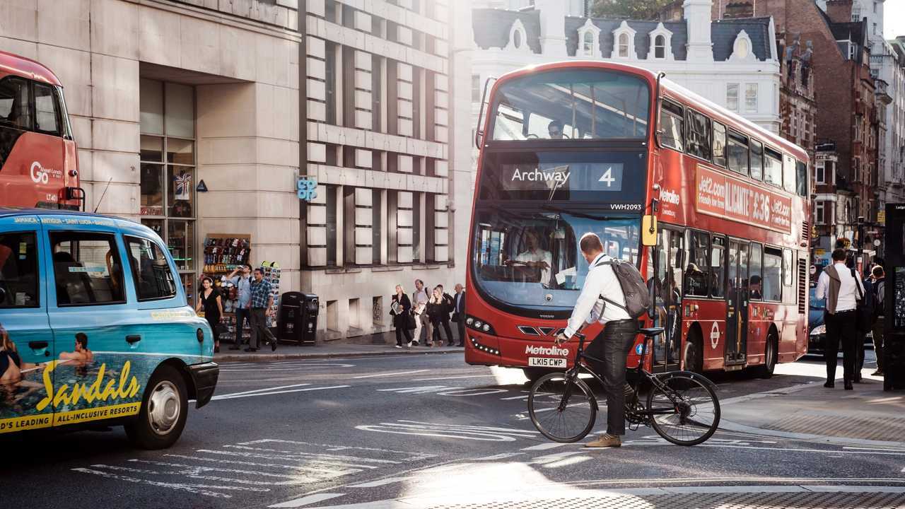 Cyclist waiting for traffic to pass on a street in London
