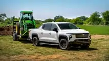 Autocarro da lavoro Chevrolet Silverado EV 2024 che traina un trattore