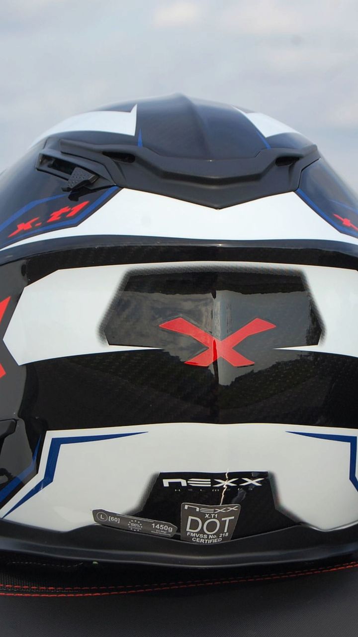 The rear view of the helmet shows the ventilation exhaust ports, molded in rear spoiler, the sun visor lever on the upper left side of the crown and the DOT FMVSS 218 certification label.