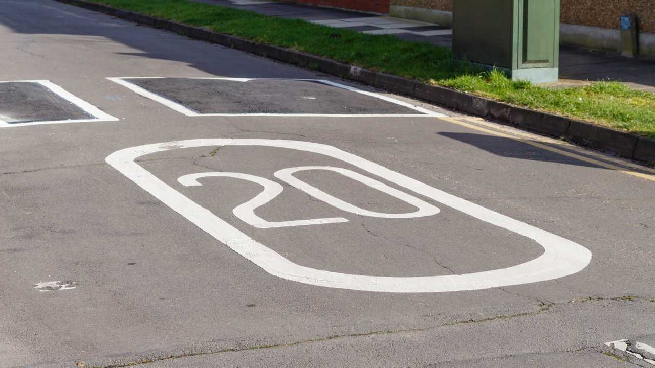 20 mph speed limit painted on road with speed bumps ahead
