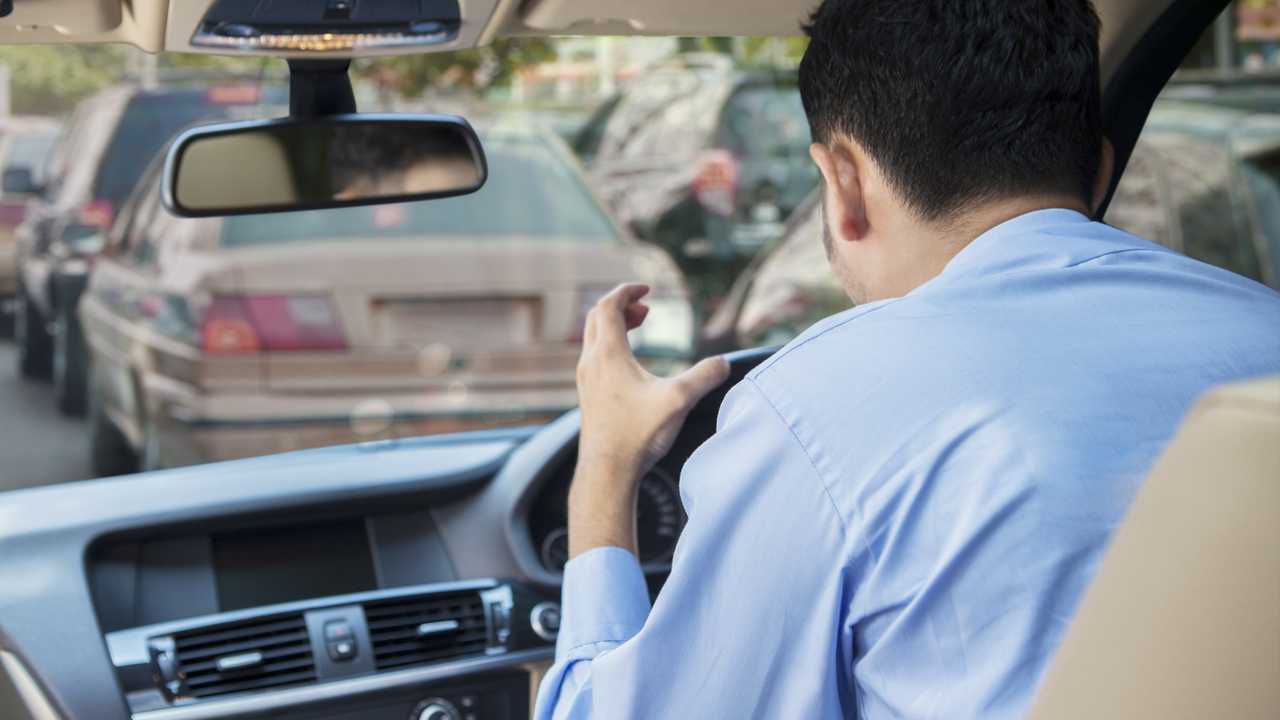 Furious man driving a car in a traffic jam