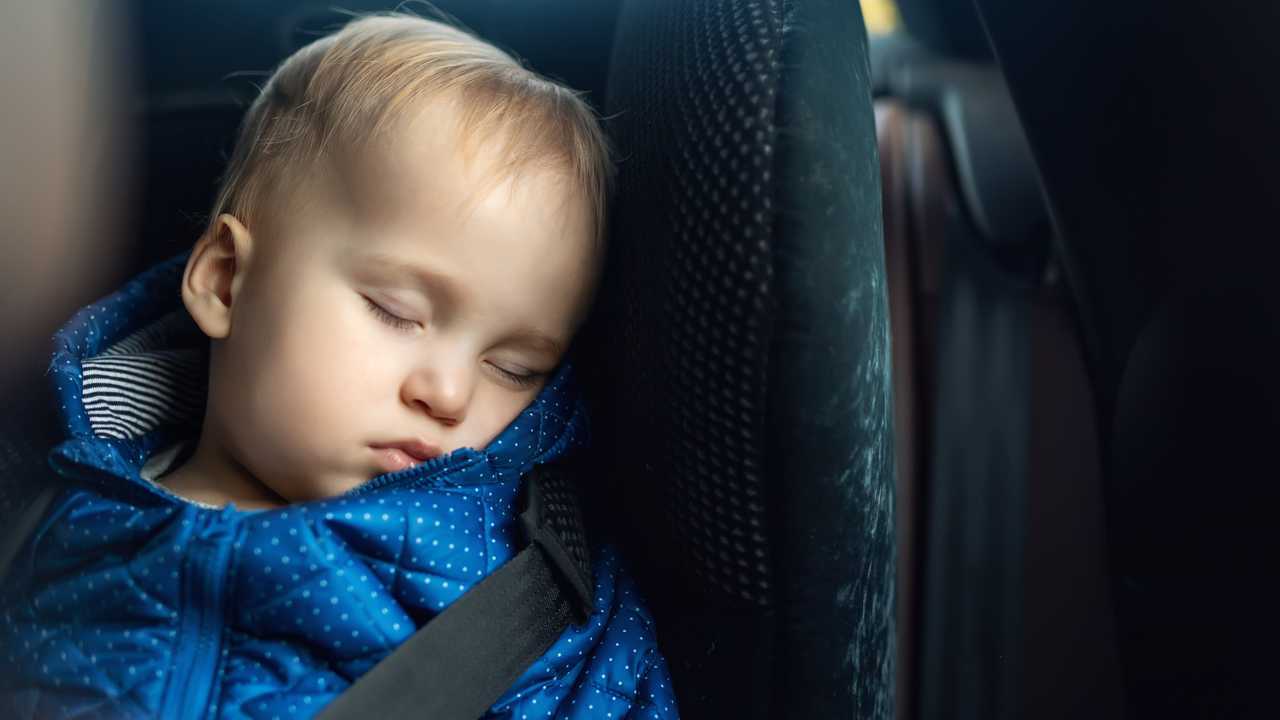 Toddler boy sleeping in child safety seat