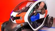Terry Gilliam posiert in einem Twizy in französischen Farben