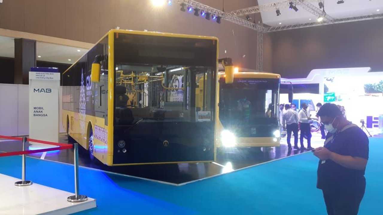 Bus listrik kuning UI (kiri) dan truk sampah lisrik dari PT MAB