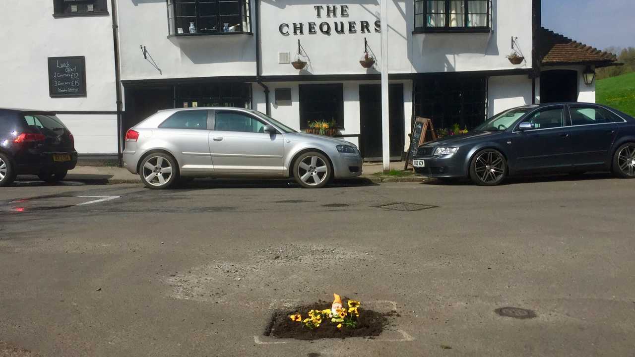 Pothole in the village of Loose has flowers planted in it Maidstone Kent UK