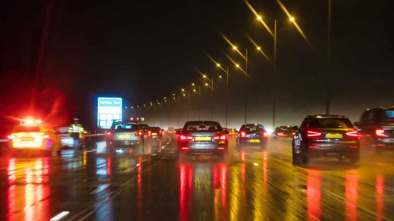 British motorway traffic at night in the rain with police car