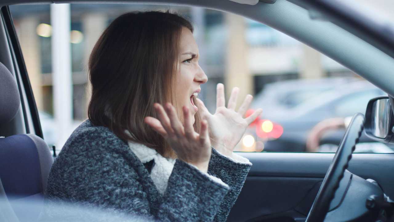 Angry woman driving her car experiencing road rage