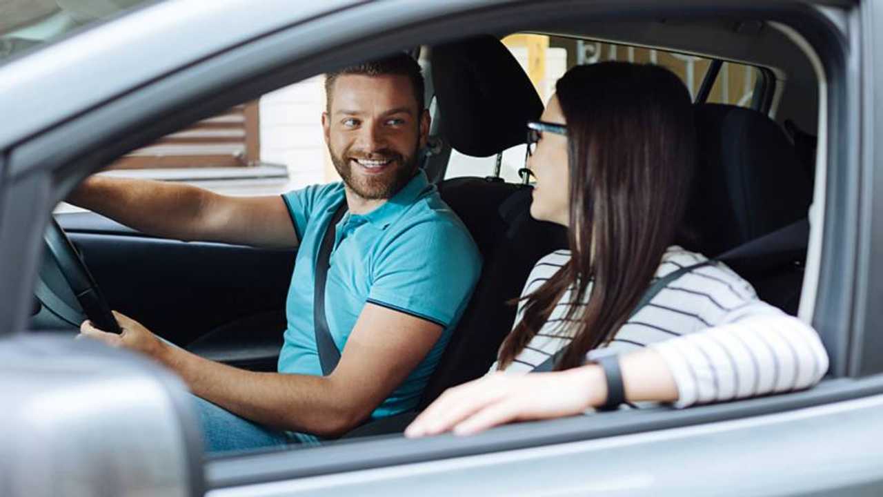 Happy couple sitting in their new car