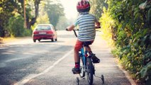 Boy riding bike on pavement sidewalk