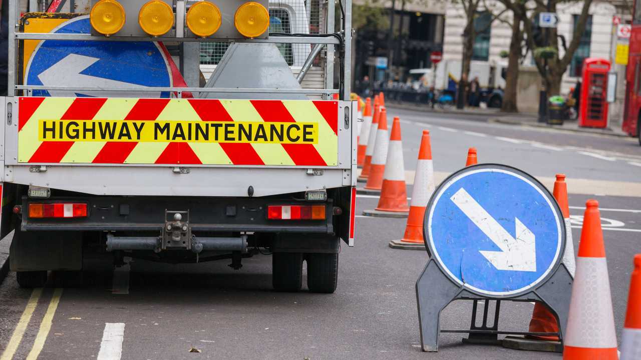 London street barricaded with Highway Maintenance vehicle and traffic cones