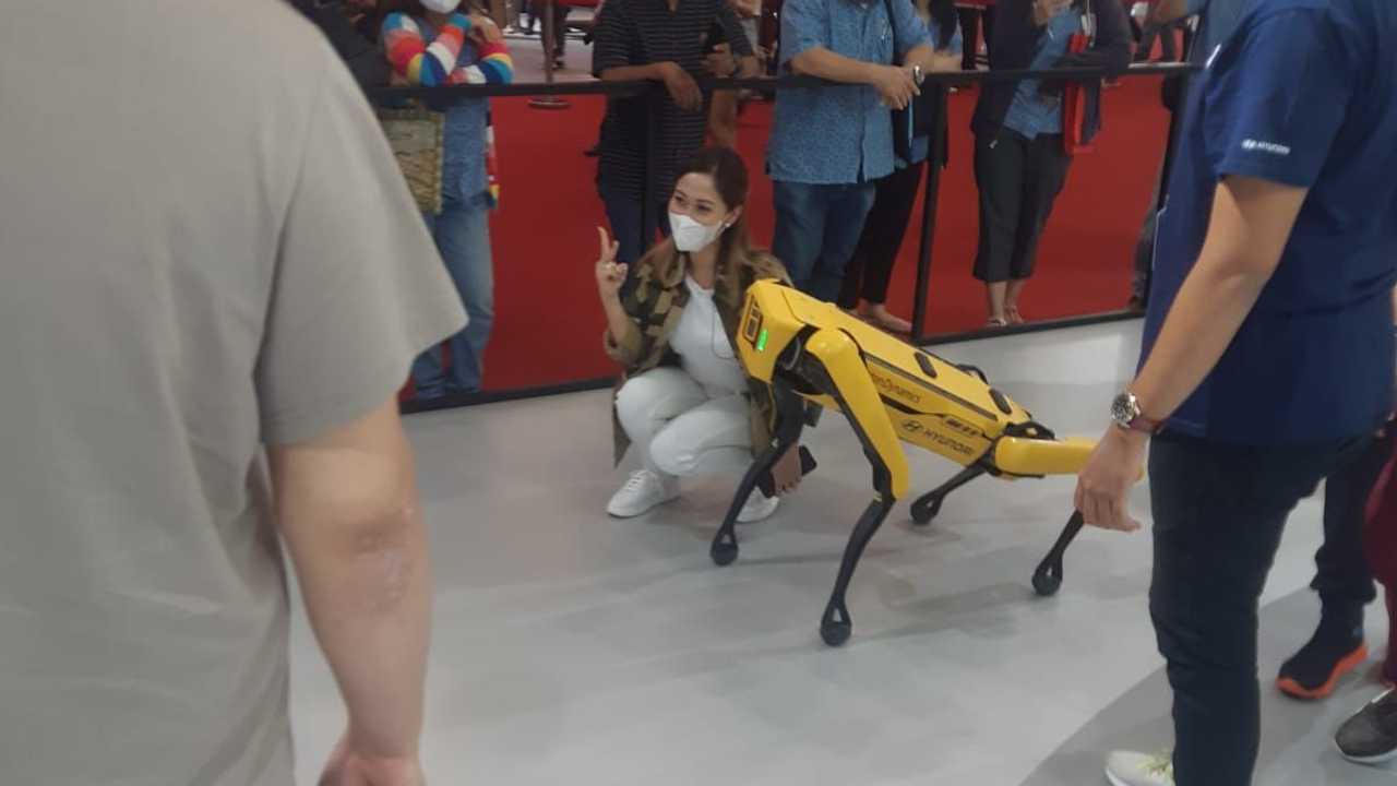 Pengunjung GIIAS 2021 berpose dengan Spot, robot anjing Hyundai.