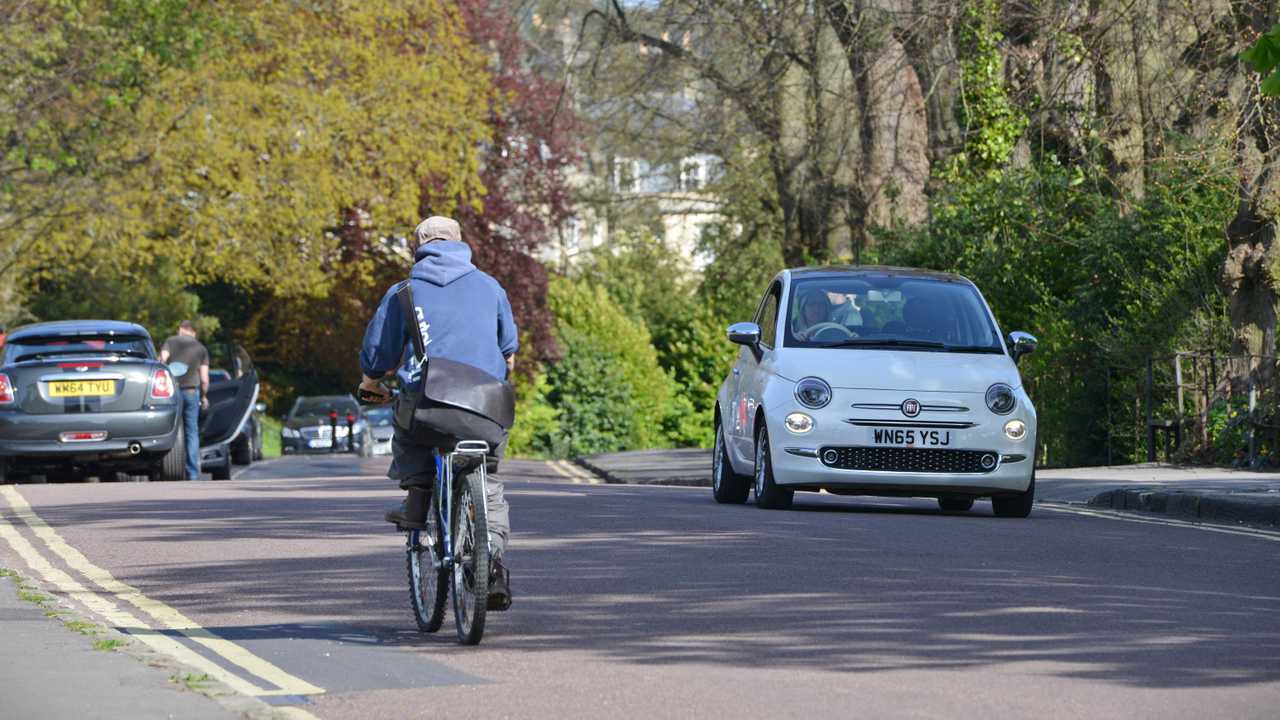 Cyclist and traffic pass through Victoria Park Bath UK
