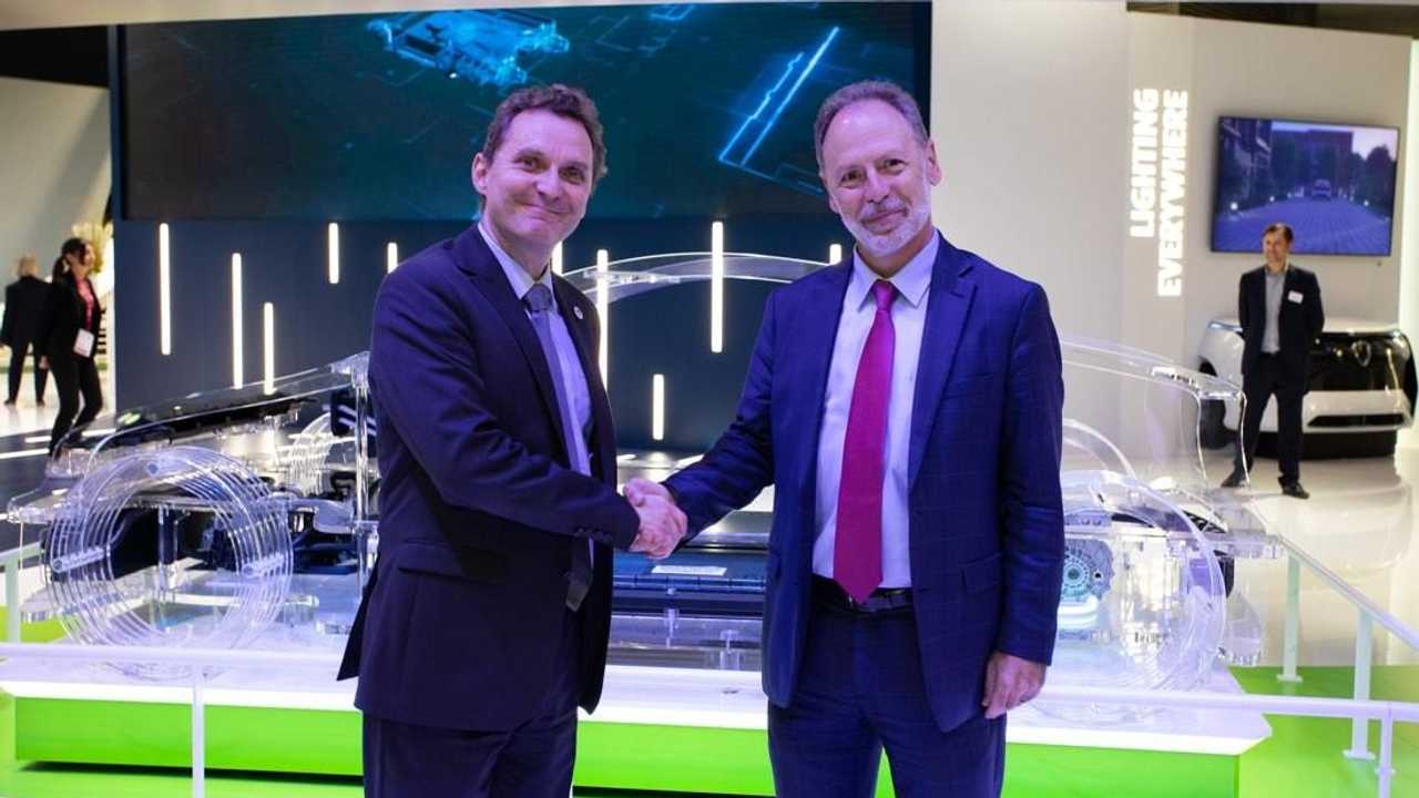 TotalEnergies-Manager Philippe Charleux (links) und Francisco Moreno von Valeo beim Handshake nach Unterzeichnung des Kooperationsvereinbarung