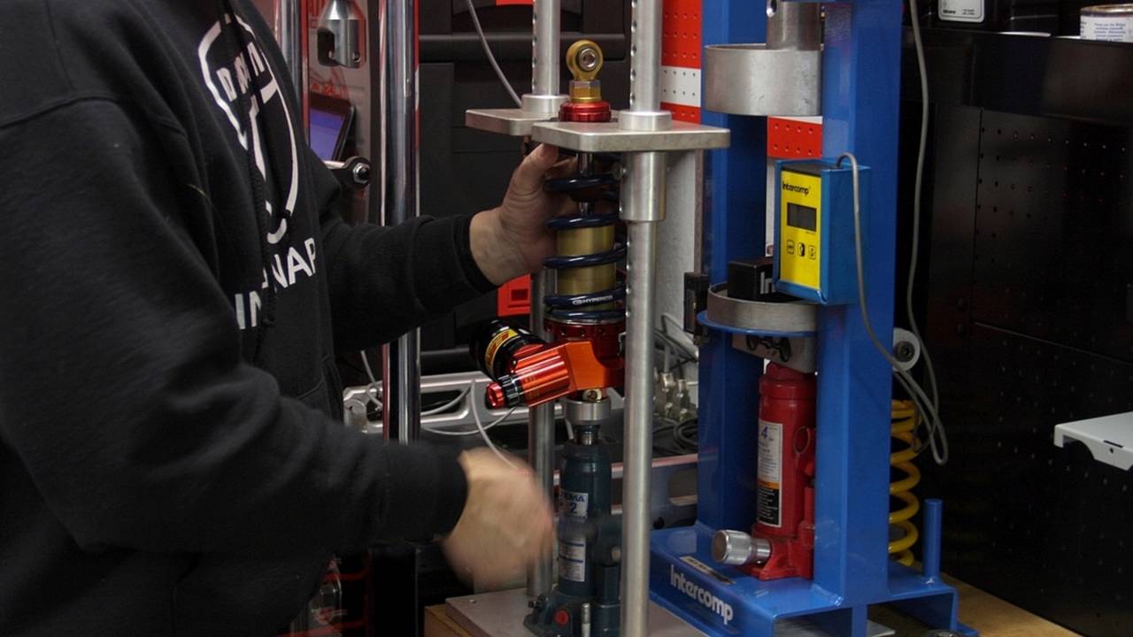 Reinstalling the spring with custom fittings on the hydraulic press.