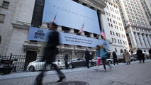 Passersby look on as General Motors' vehicles are displayed in front of the New York Stock Exchange on the morning of GM's initial public offering Thursday, November 18, 2010 in New York. (Photo by Todd Plitt for General Motors) 11/18/2010