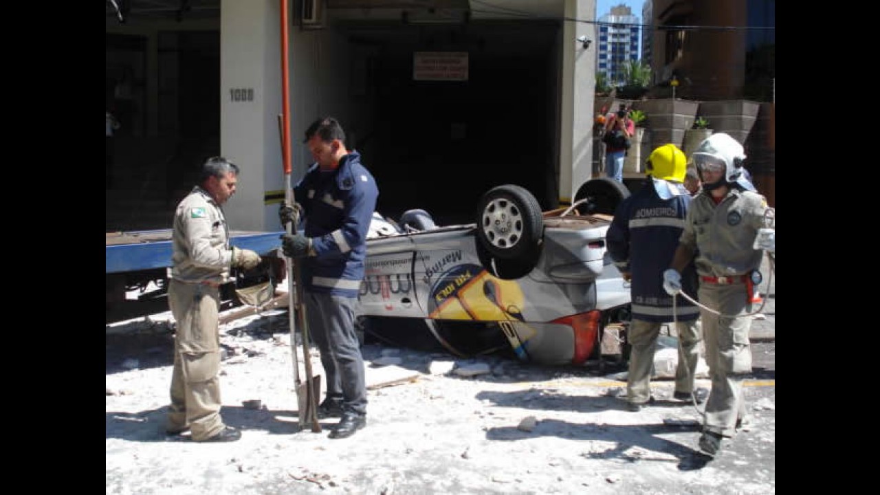 Carro cai do 3º andar de prédio e fica preso em fios de alta tensão