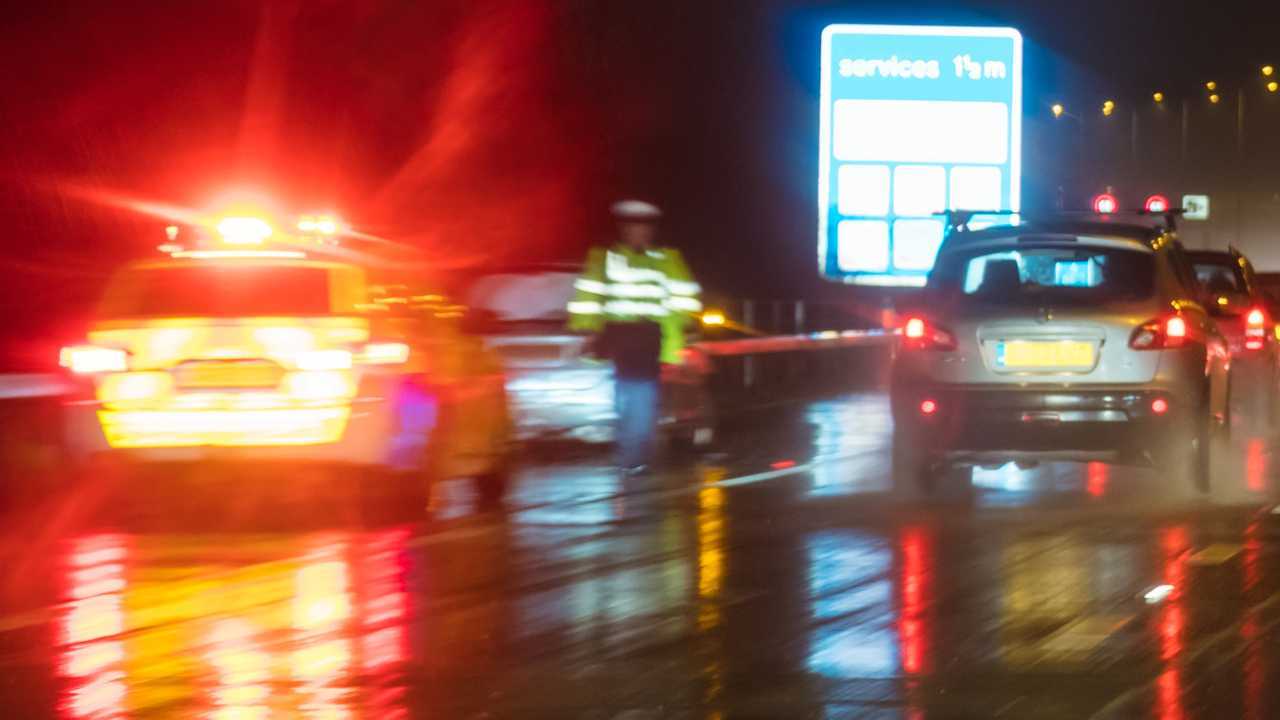 Police officer out of car during traffic stop on busy motorway