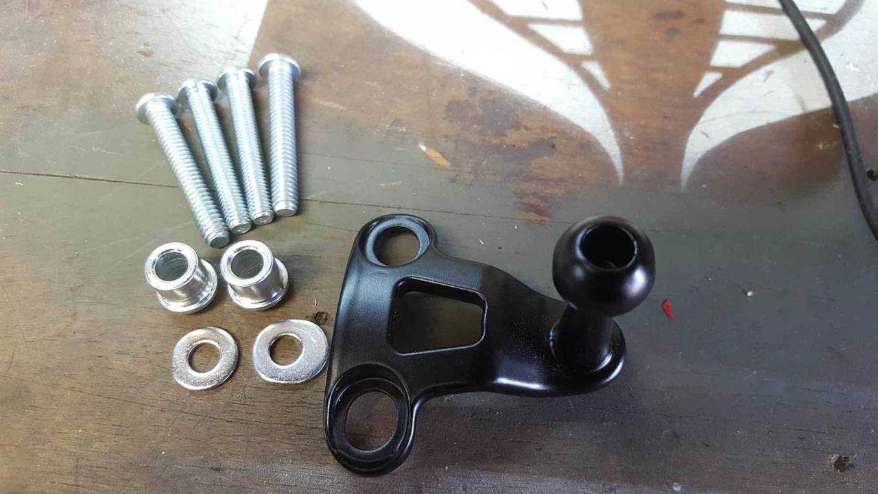 The Universal Phone Carrier Mount comes with the mount, some screws, two spacers, and two washers. Never mind that funny-shaped washer on the right, it's supposed to look like that.