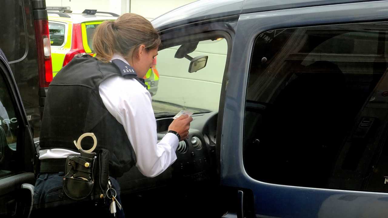 Policewoman does a check on a motorist in a London street