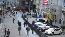 Passersby look on as General Motors' vehicles are displayed in front of the New York Stock Exchange on the morning of GM's initial public offering Thursday, November 18, 2010 in New York. (Photo by Todd Plitt for General Motors) 11/18/2010